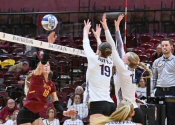 Northern State's Linnea Neisham tips the ball over the block attempt by Sioux Falls' Ella Walker (19) and Abby Haus during the third set of their match Saturday, Nov. 7 inside Wachs Arena. The Wolves were swept by the Cougars 25-19, 28-26, 25-21. Aberdeen Insider photo by Robb Garofalo.
