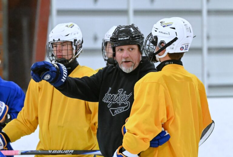 Aberdeen Cougar head boys coach Dana Myhre talks with Carter Vilhauer during practice Monday, Nov. 17 in the Hollum Expo Building. Myhre makes his coaching debut Friday, Nov. 21 against Dickinson, N.D., inside the Odde Ice Center. Aberdeen Insider photo by Robb Garofalo.