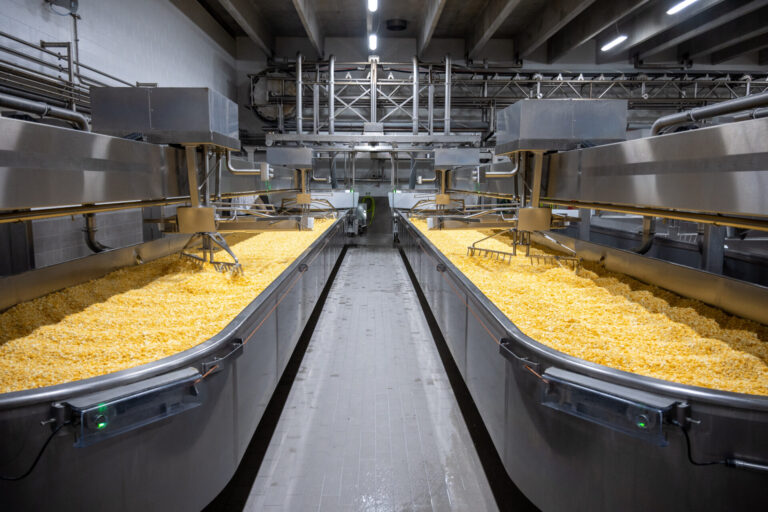 In the older section of the Queen Valley plant in Milbank, the Line 1 make-room features open tables that offer more flexibility in adding ingredients to cheese. Photo courtesy of Queen Valley.
