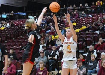 Northern State's Morgan Fiedler takes a three-pointer over Minot State's Maya Vibeto during the second quarter of their game Saturday, Dec. 6 inside Wachs Arena. Fiedler had seven points in a 68-62 Northern win. Aberdeen Insider photo by Robb Garofalo.