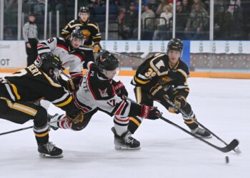 Aberdeen Wings forward Jonathan Doucette takes a shot on goal sandwiched between Austin defenseman Gus Elbert, right, and forward Siamion Marshonak during the second period of their game Saturday, Dec. 20 at the Odde Ice Center. The Wings were swept in the two-game NAHL Central Division series. Aberdeen Insider photo by Robb Garofalo.