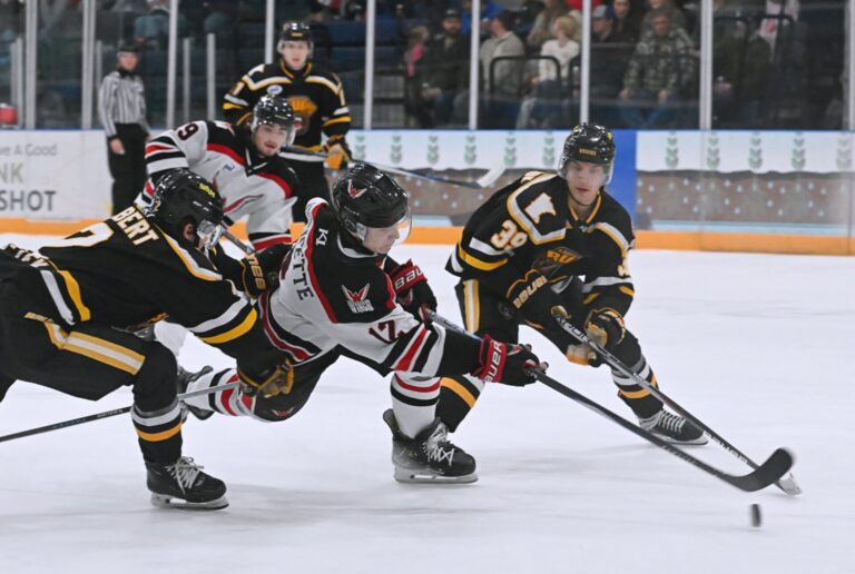 Aberdeen Wings forward Jonathan Doucette takes a shot on goal sandwiched between Austin defenseman Gus Elbert, right, and forward Siamion Marshonak during the second period of their game Saturday, Dec. 20 at the Odde Ice Center. The Wings were swept in the two-game NAHL Central Division series. Aberdeen Insider photo by Robb Garofalo.