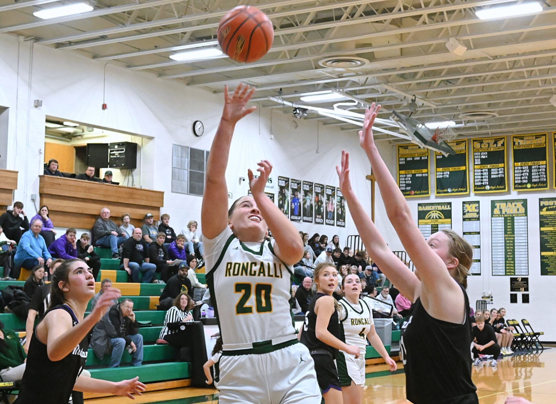Aberdeen Roncalli's Rylee Voeller attempts a layup in between Waubay/Summit's Addison Heinje, left, and Mackenzie Zubke during the third quarter of Cavalier Classic Saturday, Dec. 20 at the Roncalli Gym. Voeller had nine points, helping Roncalli to a 48-43 win. Aberdeen Insider photo by Robb Garofalo.
