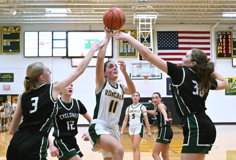 Aberdeen Roncalli's Claire Crawford drives to the rim between Clark/Willow Lake's Shelby Begeman (3) and Ella Sass during the first quarter Thursday, Jan. 22 at the Roncalli Gym. Crawford had 11 points in a 50-38 Roncalli loss. Aberdeen Insider photo by Robb Garofalo.
