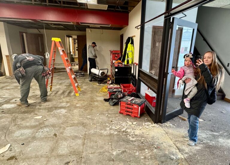Redfield Area Development Corp. director Gianna Schieffer checks on the progress of work at the Spink County Daycare being built in Redfield. With her is her daughter Maya. South Dakota News Watch photo by Bart Phankuch.