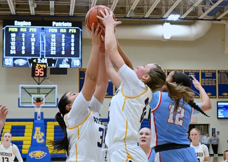 Aberdeen Central's Kennadi Withers, center, battles teammate Ashley Behrends and Sioux Falls Lincoln's Aubrianna Butler for a rebound during the fourth quarter of Central's 60-22 win Friday, Feb. 27 at Golden Eagles Arena. Withers had six points and a game-high seven rebounds. Aberdeen Insider photo by Robb Garofalo.