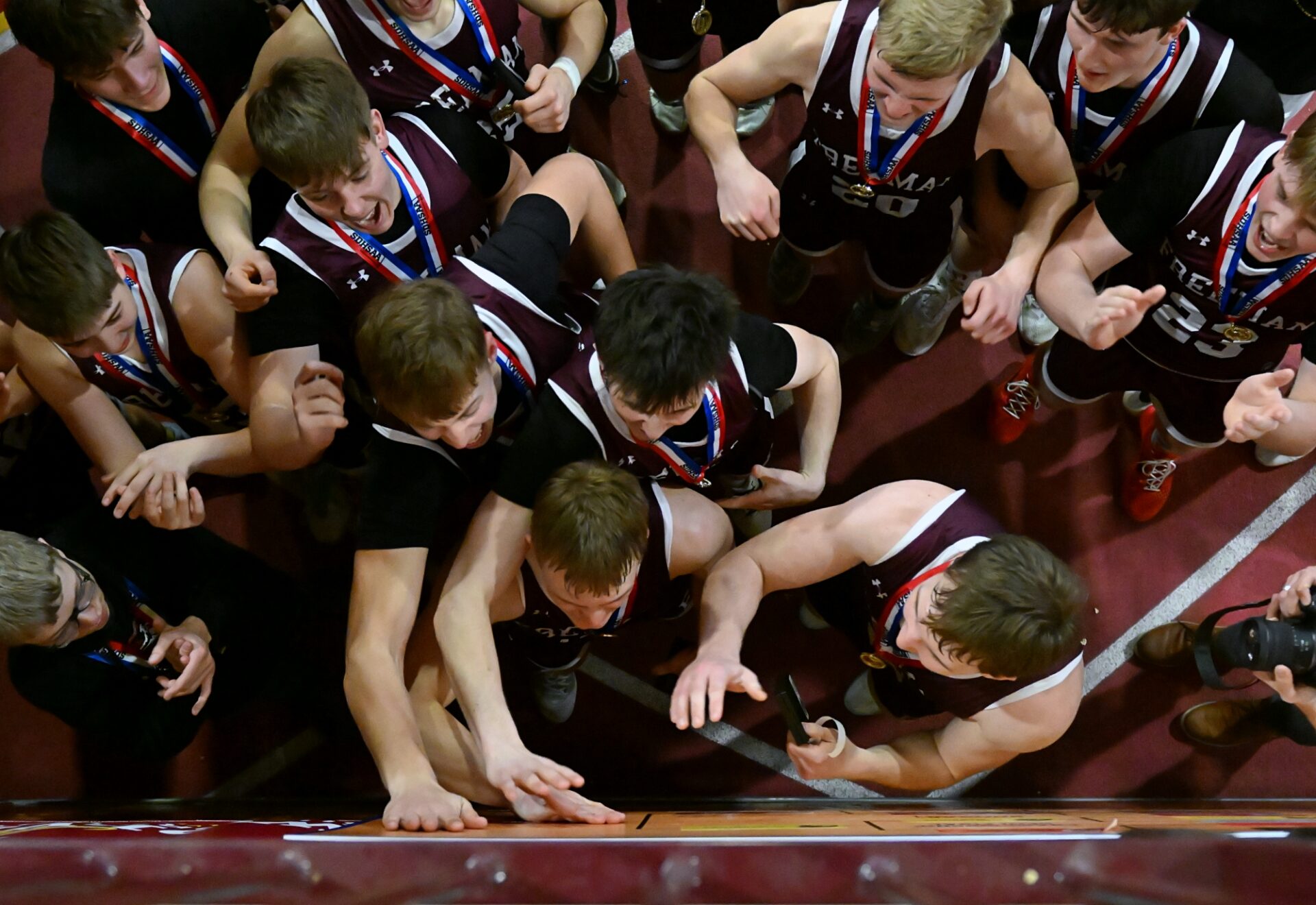 Members of the Freeman Flyers tap the State B bracket after placing their team sticker on the championship line celebrating their 61-53 state title win over Castlewood Saturday, March 21 inside the Barnett Center. It's Freeman's first title in basketball since 1975. Aberdeen Insider photo by Robb Garofalo.