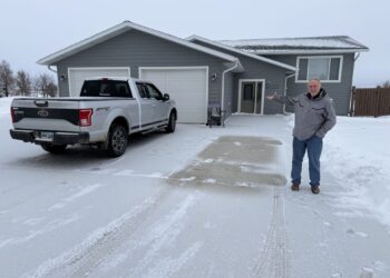 Dick Werner of the Herreid housing development group on Feb. 3 in front of an early spec home developed by the organization. South Dakota News Watch photo by Bart Pfankuch .