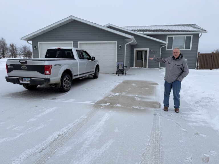Dick Werner of the Herreid housing development group on Feb. 3 in front of an early spec home developed by the organization. South Dakota News Watch photo by Bart Pfankuch .