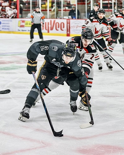 Aberdeen defenseman Cooper Anderson closes in on defensemen Gus Elbert of Austin during the opening weekend of the North American Hockey League Central Division finals last weekend in Austin, Minn. The teams split the first two games. Photo courtesy of Jeremy Elbert.