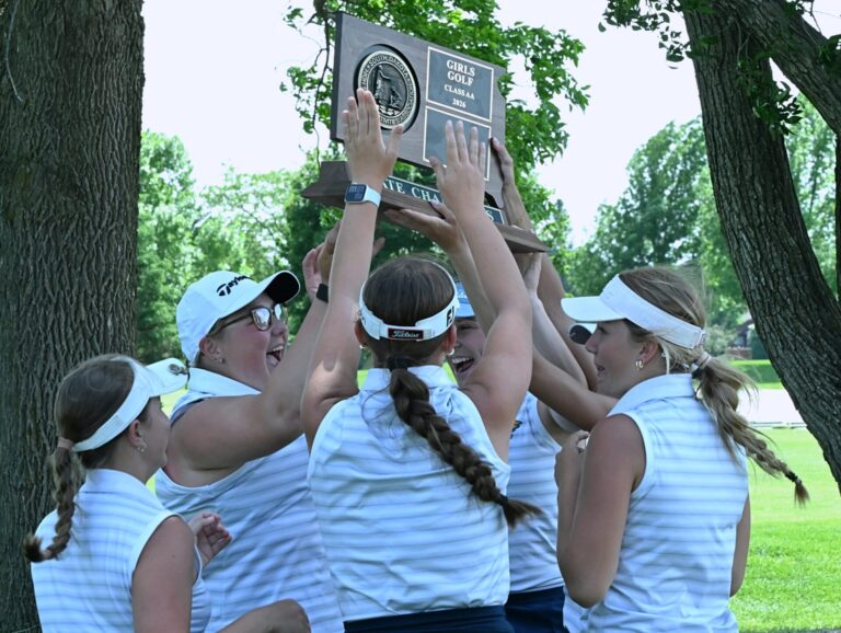 Members of the Aberdeen Central girls golf team celebrate their second-consecutive Class AA state championship Tuesday, June 2 at Cattail Crossing Golf Course in Watertown. Aberdeen Insider photo by Robb Garofalo.