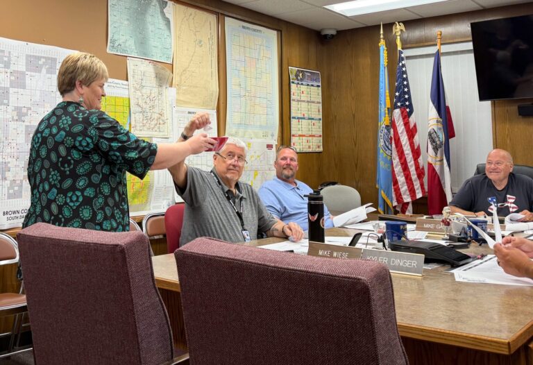 Brown County Auditor Lynn Heupel holds a bowl so County Commissioner Mike Wiese can draw a random race for an audit of the June 2 primary election, while commissioners Mike Gage, center, and Duane Sutton watch. Aberdeen insider photo by Elisa Sand.