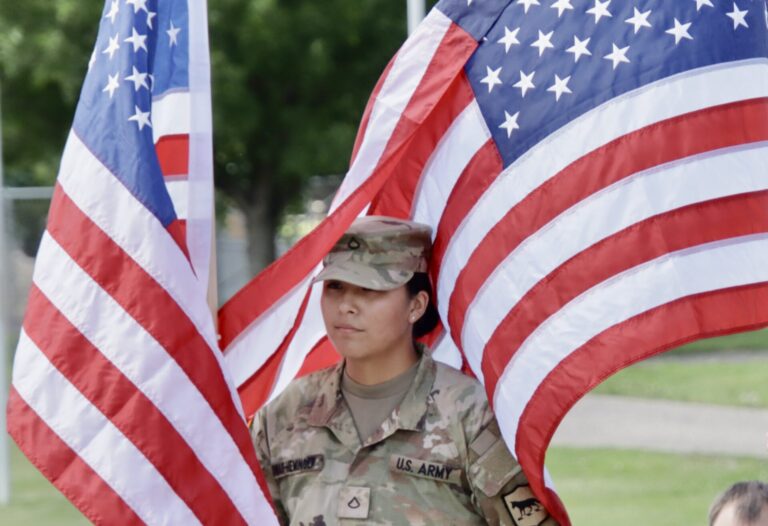 Azlyn Dwarf-Heminger of Aberdeen, a member of the South Dakota National Guard 740th Transportation Co., is surrounded by American flags during a ceremony on Friday, June 5 at Wylie Park. South Dakota's America250 flag raise raised during the event and was on display during the weekend before it was sent to Sioux Falls. Aberdeen Insider photo by Scott Waltman.