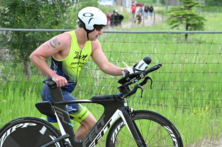 Aberdeen's Tony Schwan pushes his bike towards the riding zone on U.S. Highway 281 during the Hub City Triathlon Saturday, June 27 at Dahme Lake. Aberdeen Insider photo by Robb Garofalo.