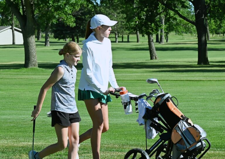Mackenzie Wegehaupt caddies for younger sister Madison during the South Dakota Golf Association Junior Tour event Tuesday, June 30 at Lee Park Golf Course. Aberdeen Insider photo by Robb Garofalo.