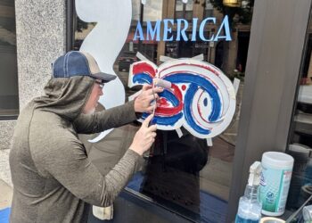 Brian Schuck of Artful Aberdeen paints an exterior window on a building near the Capitol Theatre in downtown Aberdeen. It was one of about 15 window paintings in advance of Independence Day, when the U.S. will celebrate its 250th anniversary. One of the main local activities is a parade through downtown that begins at 10 a.m. on Saturday, July 4. Schuck was doing the painting for the Aberdeen Downtown Association. Aberdeen Insider photo by Scott Waltman.
