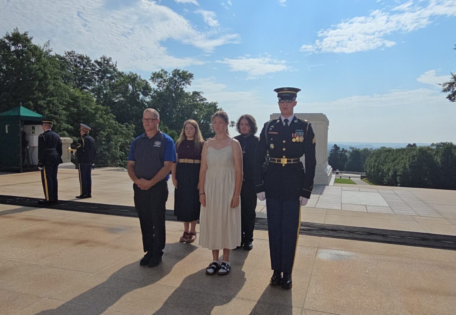 Central band director Jeremy Schutter, left, and students Hailey Steckelberg, Annabelle McDaniel and Louis Manhart stand in formation with a guard after laying a wreath on the Tomb of the Unknown Soldier on Sunday, July 5. Courtesy photo.