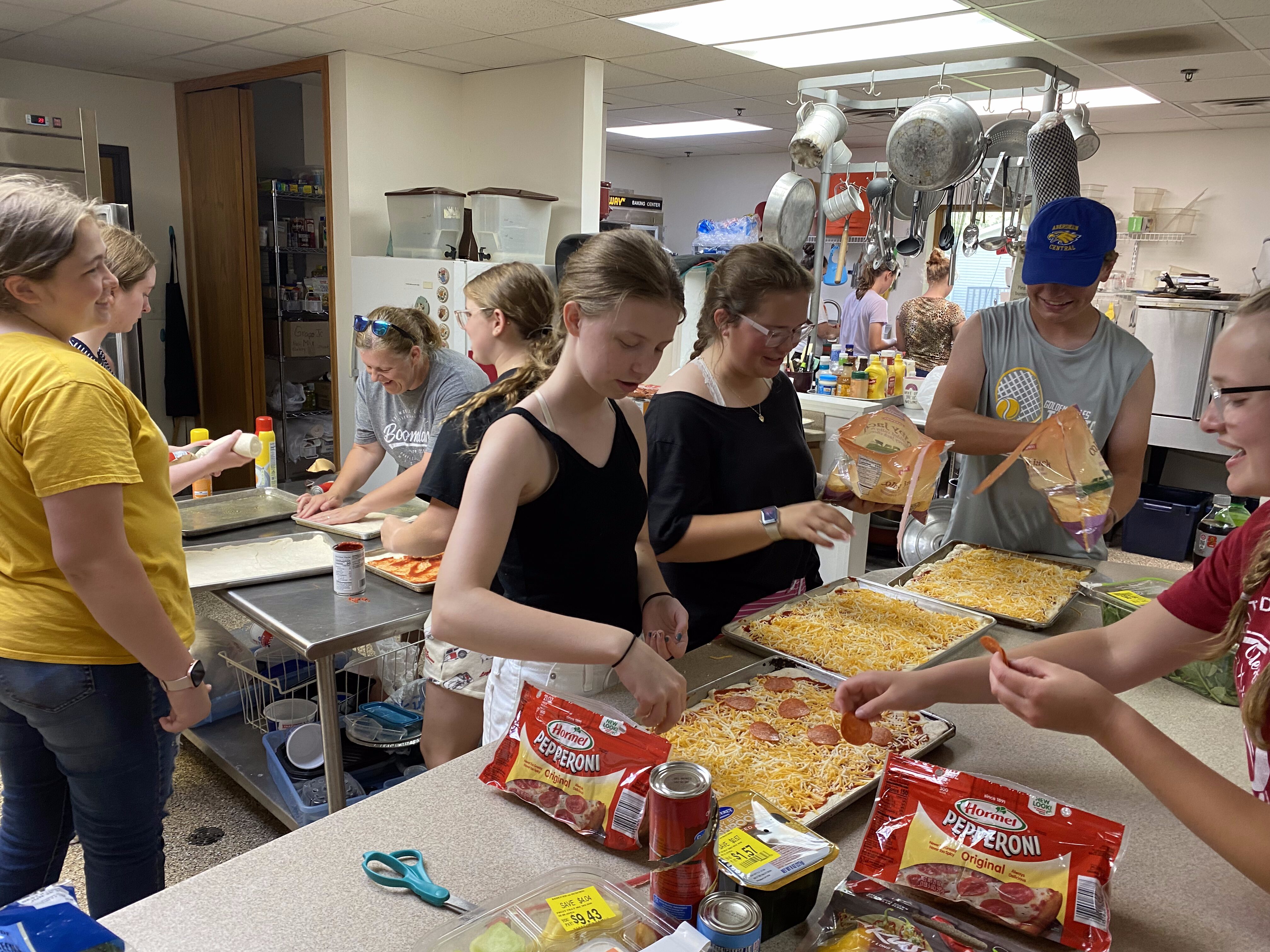 Central High School students and chaperones make pizzas in a church kitchen after their bus broke down in Iowa. The school's marching band traveled to Washington, D.C., for Independence Day. Courtesy photo.