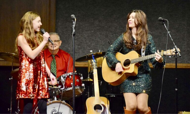Eden Barkmeier, left, sings while her mother, Jennifer Barkmeier, plays guitar doing a December 2025 show with Sherwin Linton at the Redlin Art Center in Watertown. Photo courtesy of The Watertown Current.