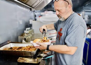 Troy Hofer prepares an order inside the Triple T Grill and Catering food trailer during the downtown event on Thursday, July 2. Aberdeen Insider photo by Jason Lopez Martinez.