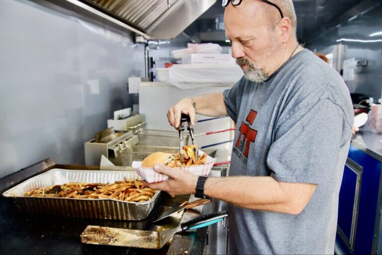 Troy Hofer prepares an order inside the Triple T Grill and Catering food trailer during the downtown event on Thursday, July 2. Aberdeen Insider photo by Jason Lopez Martinez.