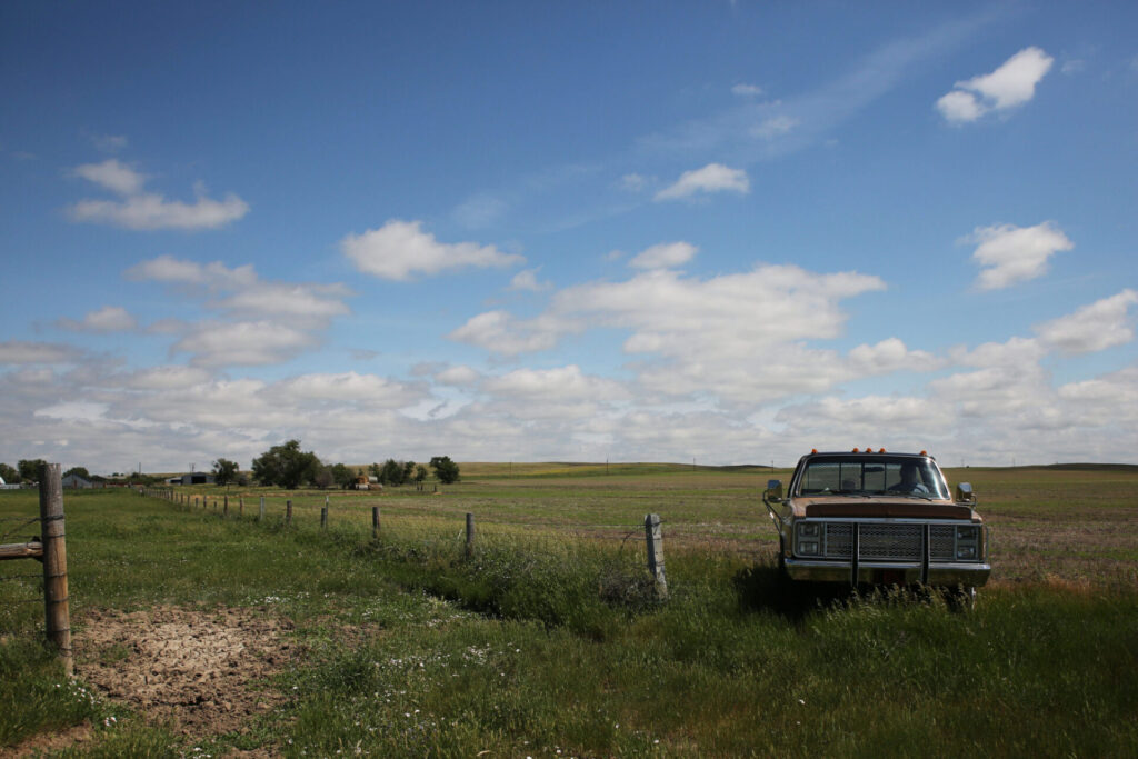 South Dakota Gov. Larry Rhoden drives his 1986 Chevy Silverado pickup on his rural Union Center ranch on June 26. South Dakota Searchlight phot by Makenzie Huber.