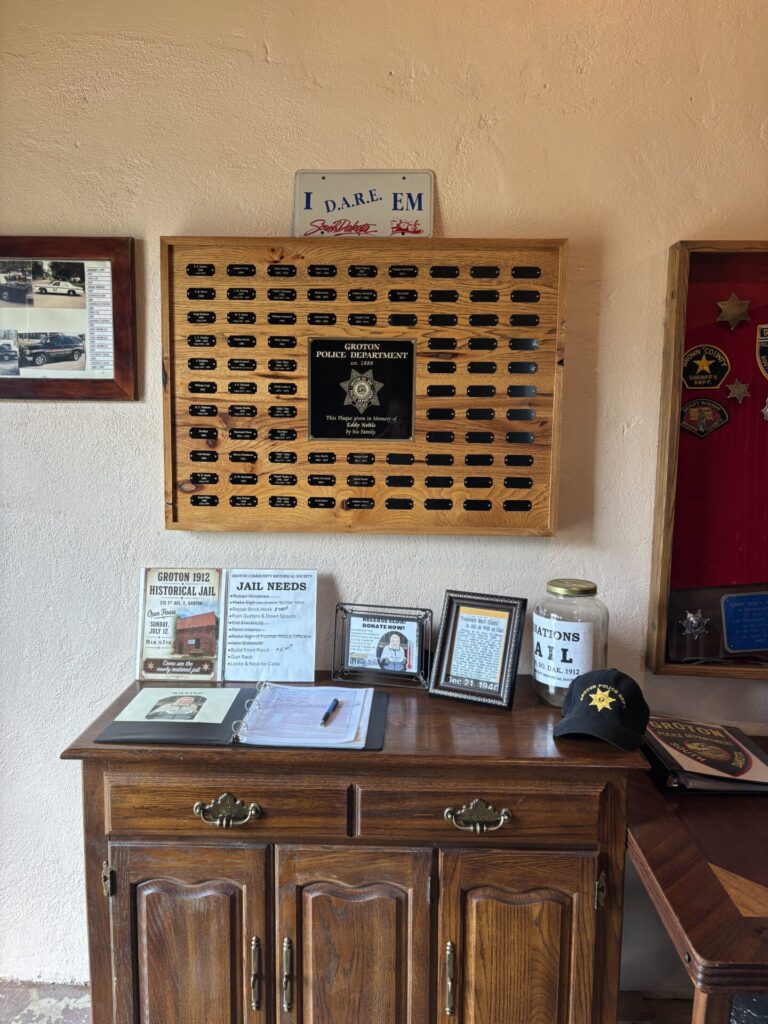 Topper Tastad and the Nehls family created a display to honor Groton police, including a plaque, badges, photos and more. Aberdeen Insider photo by Paige Schmidt.