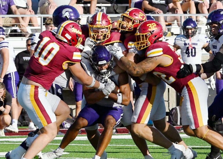 Northern State's Cooper Logan, 10 along with teammates Ayden Barnby, Kale Johnson and Gabe Gutierrez gang-tackle Winona State's Noah Smith for no gain during the first quarter of the Wolves 31-16 win Thursday, Sept. 3 at Dacotah Bank Stadium. Aberdeen Insider photo by Robb Garofalo.