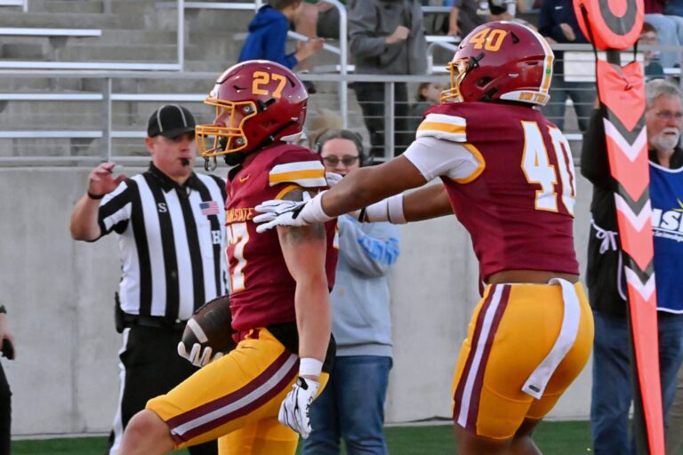 Northern State's Kale Johnson (27) and Jackson Waitkus celebrate Johnson's touchdown in the second quarter of the Wolves 16-9 win over Bemidji State. Waitkus blocked a punt, and Johnson grabbed it at the 5-yard and ran it in for the score. Aberdeen Insider photo by Robb Garofalo.